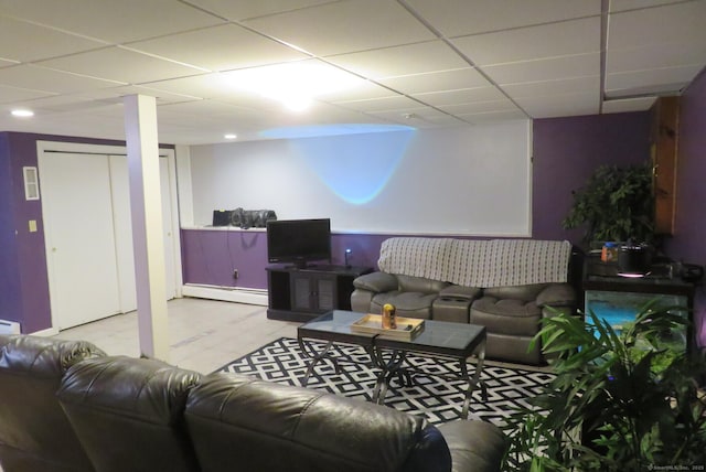 living room with baseboard heating and a drop ceiling