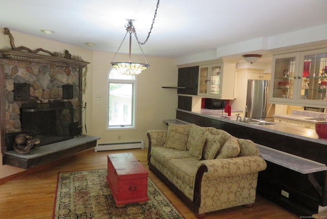 living room with a baseboard heating unit and wood finished floors