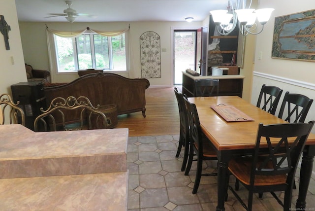 dining area with a chandelier, a ceiling fan, and wood finished floors