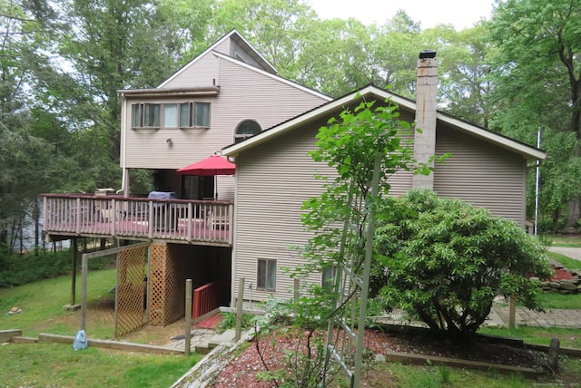rear view of property with a wooden deck and a chimney