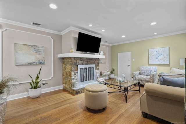 living area with ornamental molding, wood finished floors, baseboards, recessed lighting, and a fireplace