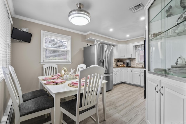 dining space featuring plenty of natural light, ornamental molding, recessed lighting, and light wood-type flooring