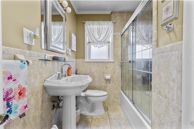 full bath featuring tile walls, tile patterned floors, shower / bath combination with glass door, toilet, and ornamental molding