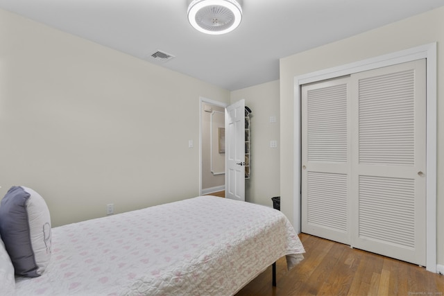 bedroom with wood finished floors and a closet