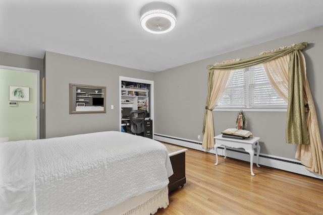bedroom featuring light wood-style floors and baseboard heating
