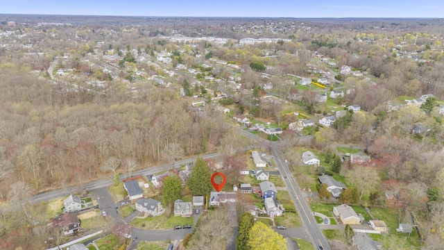 view of property location with nearby suburban area and a forest