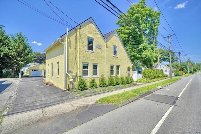 661 E Main St, Stratford, CT 06614 - view of side of property featuring stucco siding and a garage