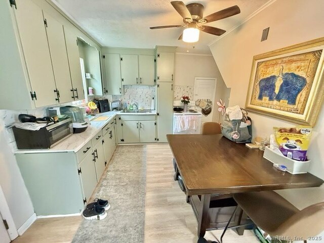 661 E Main St, Stratford, CT 06614 - kitchen featuring black microwave, tasteful backsplash, ceiling fan, light wood finished floors, and light countertops