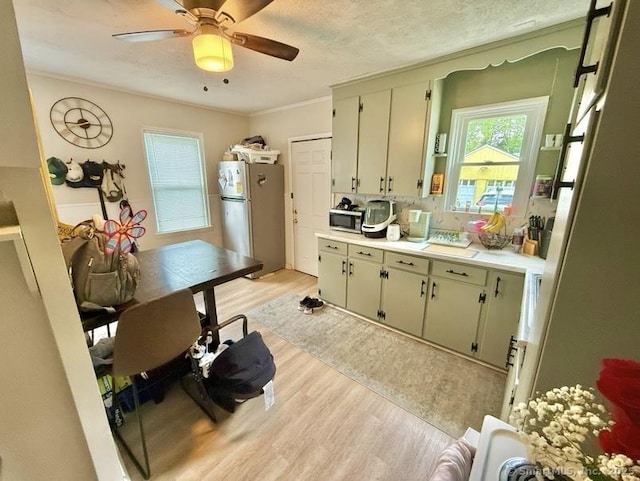 661 E Main St, Stratford, CT 06614 - kitchen featuring stainless steel appliances, light wood finished floors, light countertops, ceiling fan, and ornamental molding