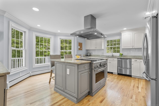 94 Glen Dr, New Canaan, CT 06840 - kitchen with appliances with stainless steel finishes, island exhaust hood, crown molding, white cabinets, and light wood-style flooring