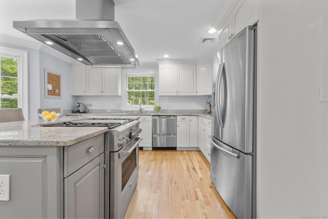 94 Glen Dr, New Canaan, CT 06840 - kitchen with appliances with stainless steel finishes, extractor fan, white cabinets, light wood-style floors, and recessed lighting