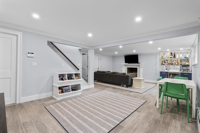 94 Glen Dr, New Canaan, CT 06840 - playroom with ornamental molding, light wood finished floors, a fireplace, baseboards, and recessed lighting