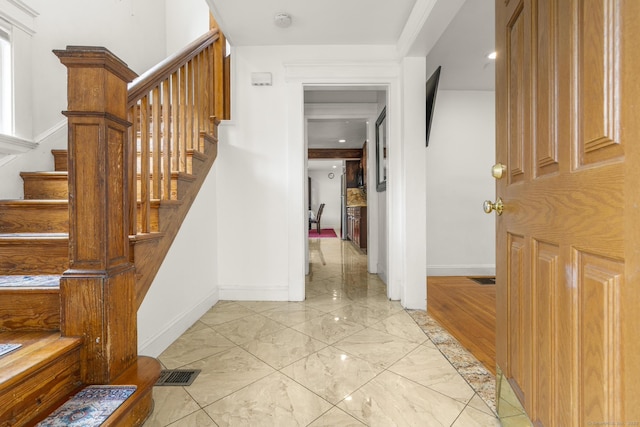 stairway featuring baseboards and marble finish flooring