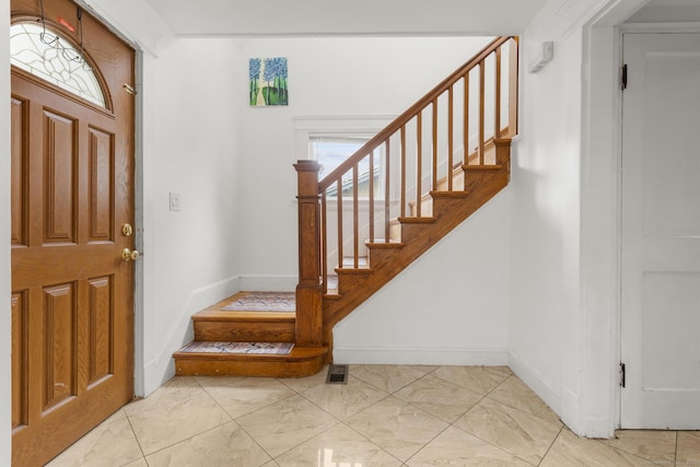 entrance foyer featuring stairway and baseboards