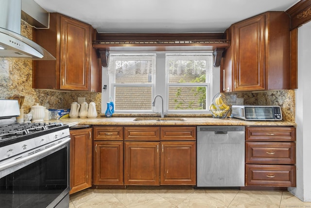 kitchen featuring appliances with stainless steel finishes, a sink, wall chimney exhaust hood, decorative backsplash, and light marble finish floors