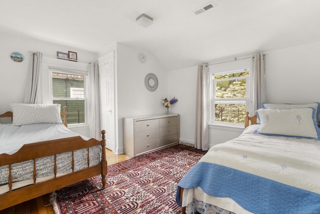 bedroom featuring lofted ceiling and baseboards
