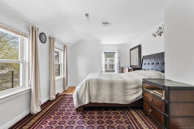 bedroom featuring lofted ceiling and baseboards