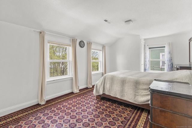 bedroom with lofted ceiling, baseboards, and dark colored carpet