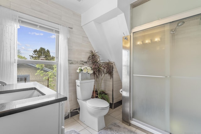 bathroom with toilet, tile walls, tile patterned flooring, a stall shower, and vanity