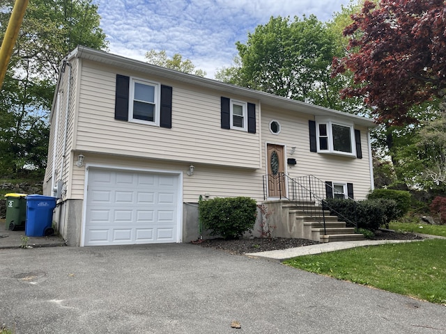 split foyer home with a garage and asphalt driveway