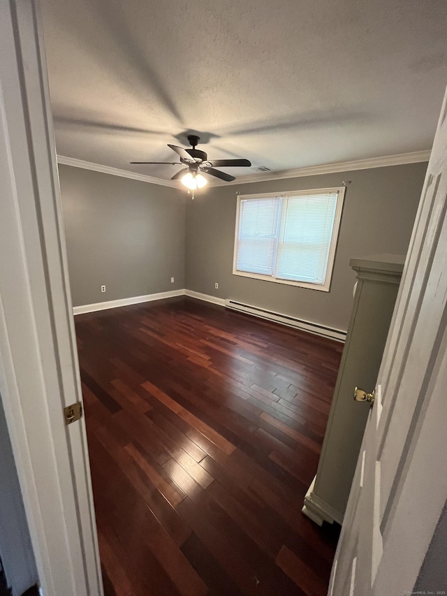 unfurnished room with a baseboard heating unit, ornamental molding, ceiling fan, dark wood-style floors, and baseboards