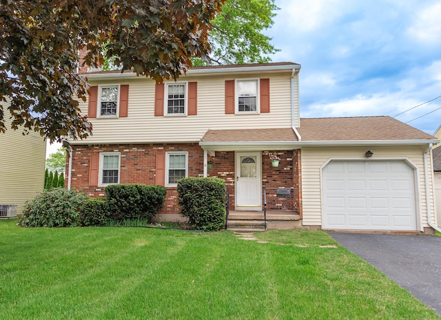 view of front of home featuring asphalt driveway, a garage, a front yard, and brick siding