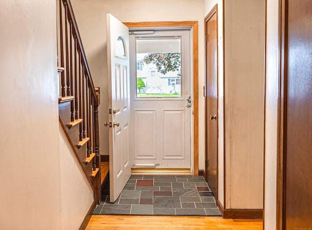 doorway featuring stairs and dark stone finish flooring