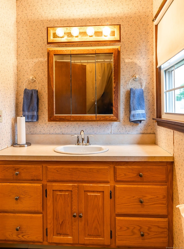 bathroom featuring wallpapered walls and vanity