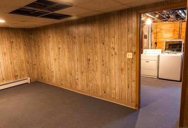 spare room with separate washer and dryer, wood walls, and dark colored carpet