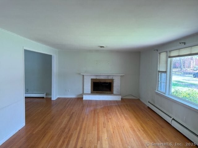 6 Spencer Pl, New Haven, CT 06515 - unfurnished living room with a baseboard heating unit, light wood finished floors, a fireplace, and baseboards