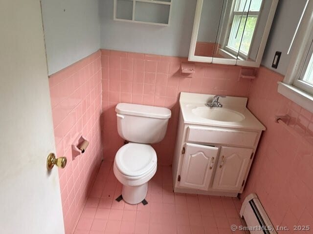 6 Spencer Pl, New Haven, CT 06515 - half bathroom featuring baseboard heating, tile walls, toilet, a wainscoted wall, and vanity
