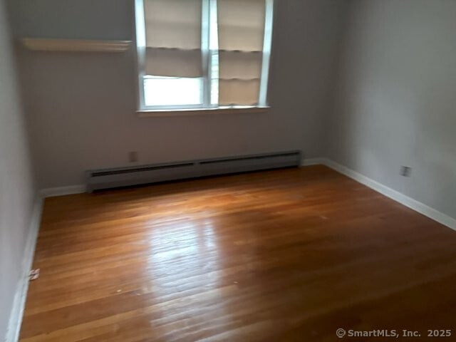 6 Spencer Pl, New Haven, CT 06515 - empty room featuring a baseboard heating unit, wood finished floors, and baseboards