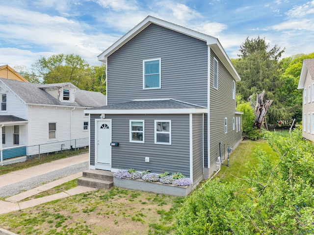 view of front of home featuring fence and a shingled roof