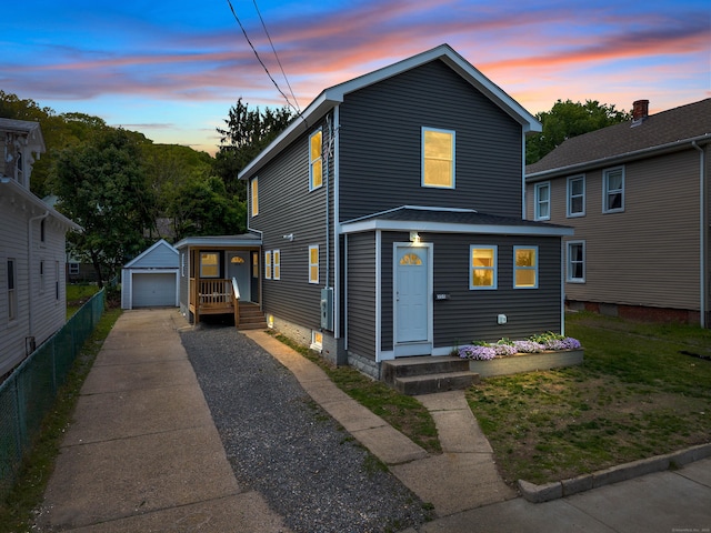 view of front of home featuring driveway, an outdoor structure, a garage, and fence