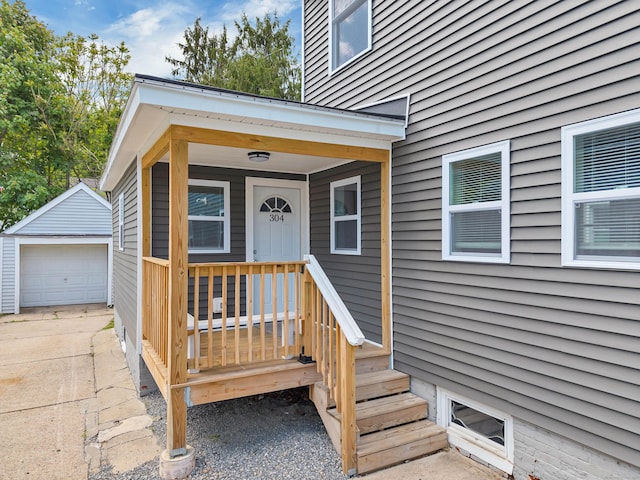 doorway to property featuring a detached garage and driveway