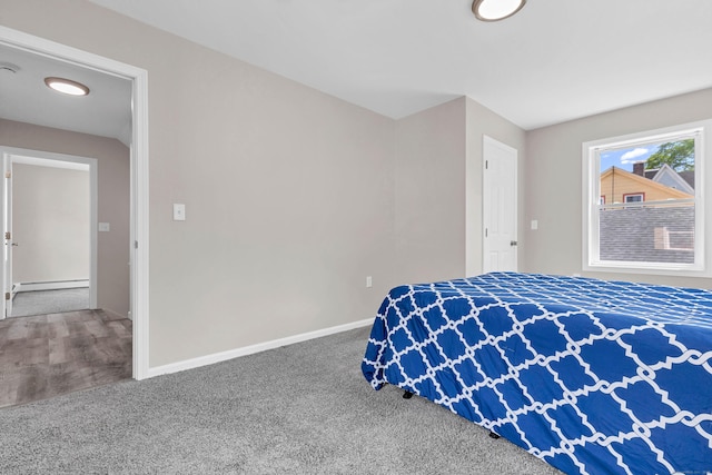 bedroom with baseboard heating, baseboards, and carpet flooring