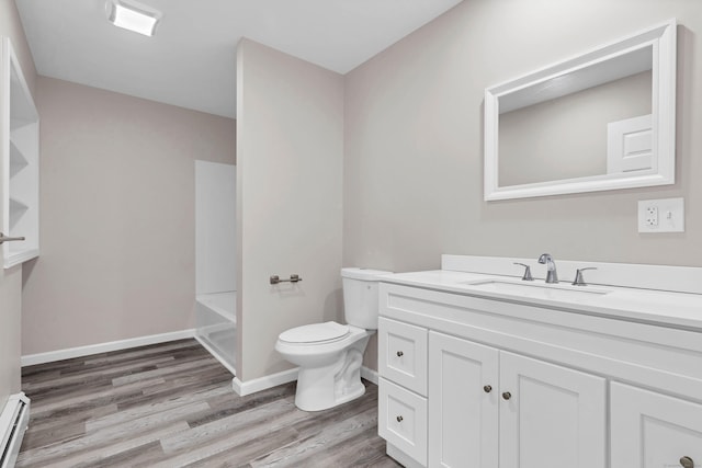 bathroom featuring toilet, wood finished floors, vanity, a baseboard radiator, and baseboards
