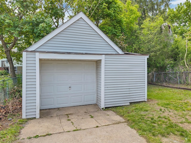 detached garage with fence and driveway