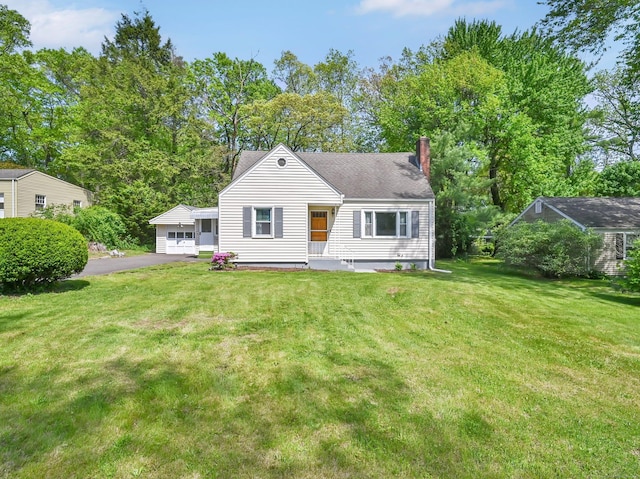 view of front of house featuring a chimney and a front lawn