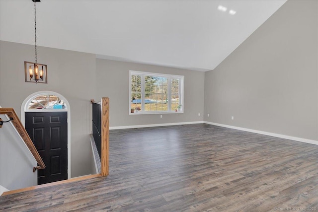 unfurnished living room with a chandelier, wood finished floors, high vaulted ceiling, and baseboards