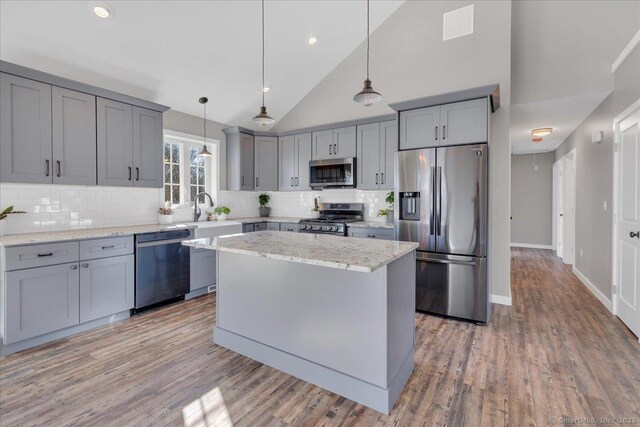 59 Chapin Ave, Rocky Hill, CT 06067 - kitchen featuring appliances with stainless steel finishes, gray cabinetry, tasteful backsplash, light wood finished floors, and light stone counters