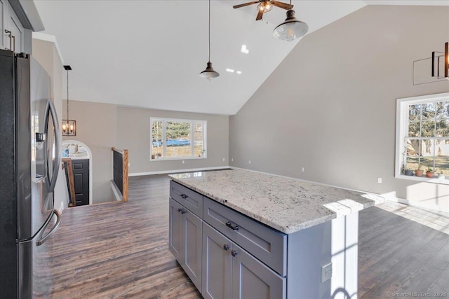 kitchen featuring stainless steel fridge, open floor plan, dark wood-style floors, high vaulted ceiling, and gray cabinets