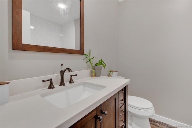 bathroom with vanity, toilet, and wood finished floors