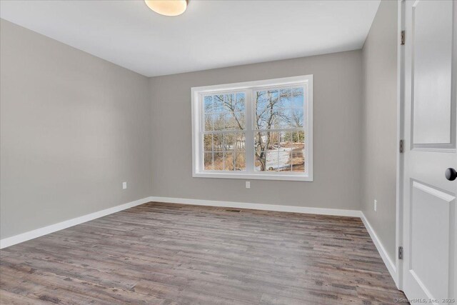 empty room with wood finished floors and baseboards