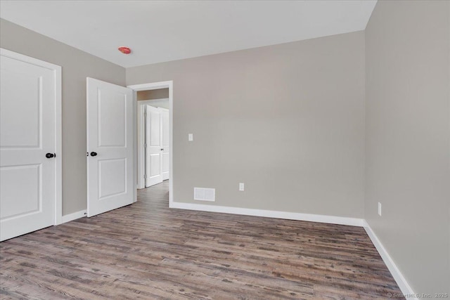 unfurnished bedroom with wood finished floors and baseboards