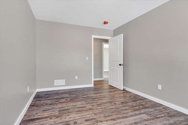 spare room with wood finished floors and baseboards