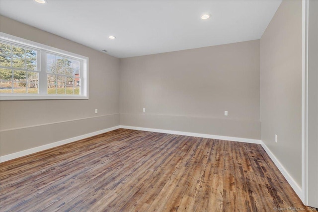 unfurnished room featuring baseboards, wood finished floors, and recessed lighting
