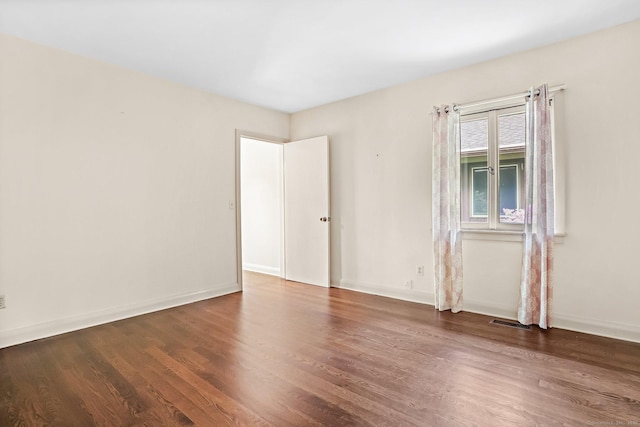spare room with wood finished floors and baseboards
