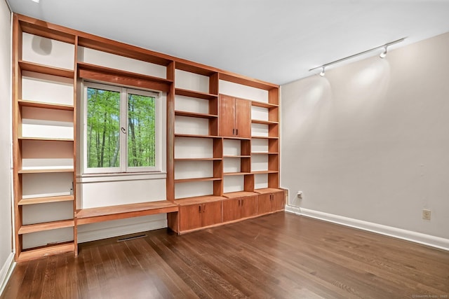 unfurnished room featuring rail lighting, dark wood-style flooring, and baseboards