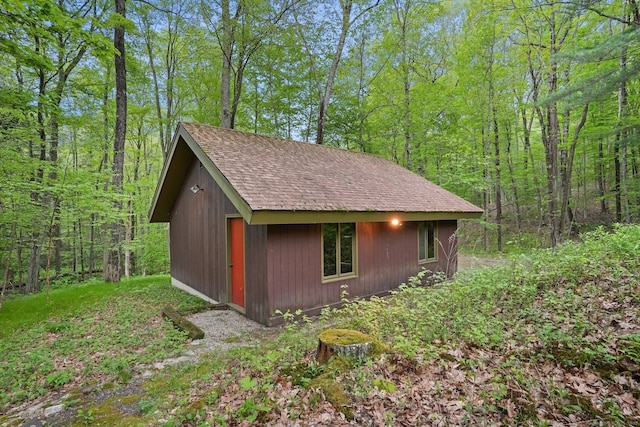 view of outdoor structure with an outbuilding and a wooded view